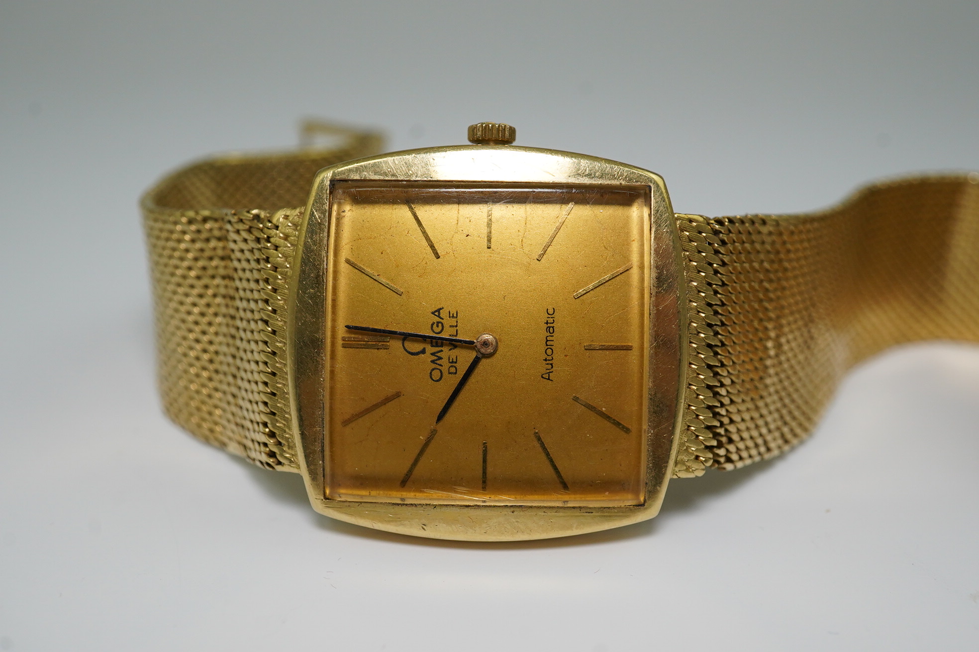 A gentleman's early 1960's 18ct gold Omega De Ville automatic dress wrist watch, on integral Omega 18ct gold mesh link bracelet